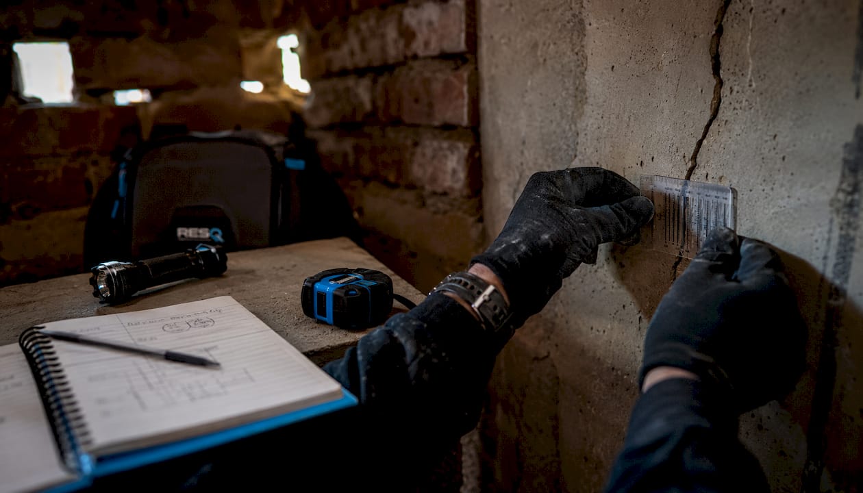 Inspector measuring foundation crack