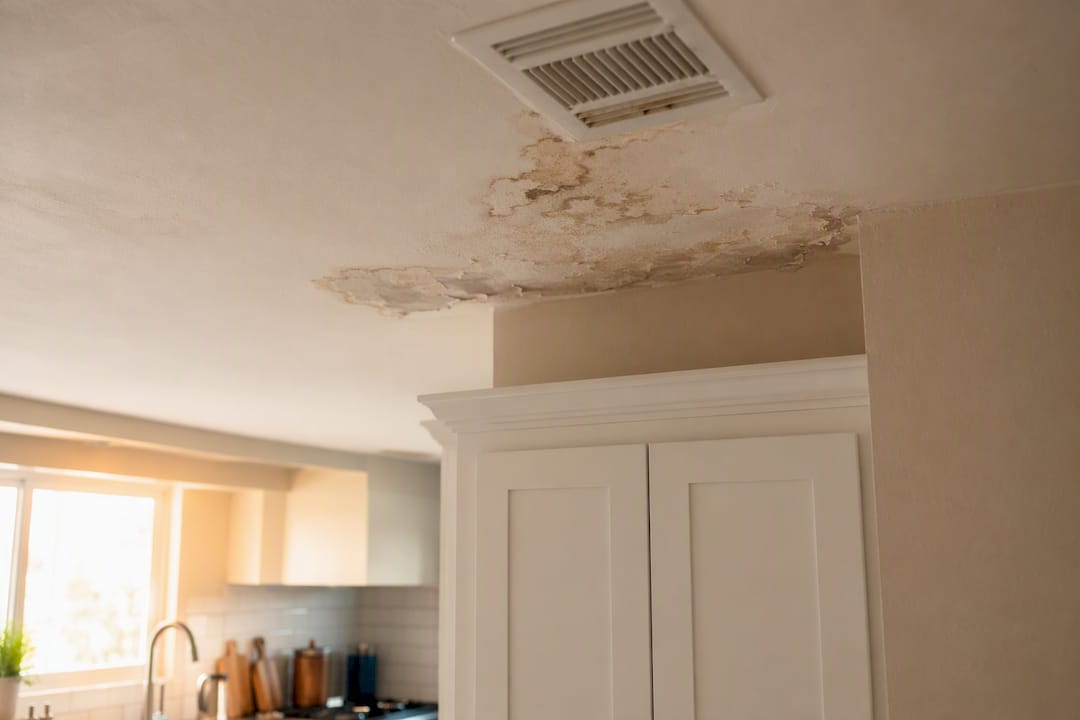 Brown water stains on ceiling below duct
