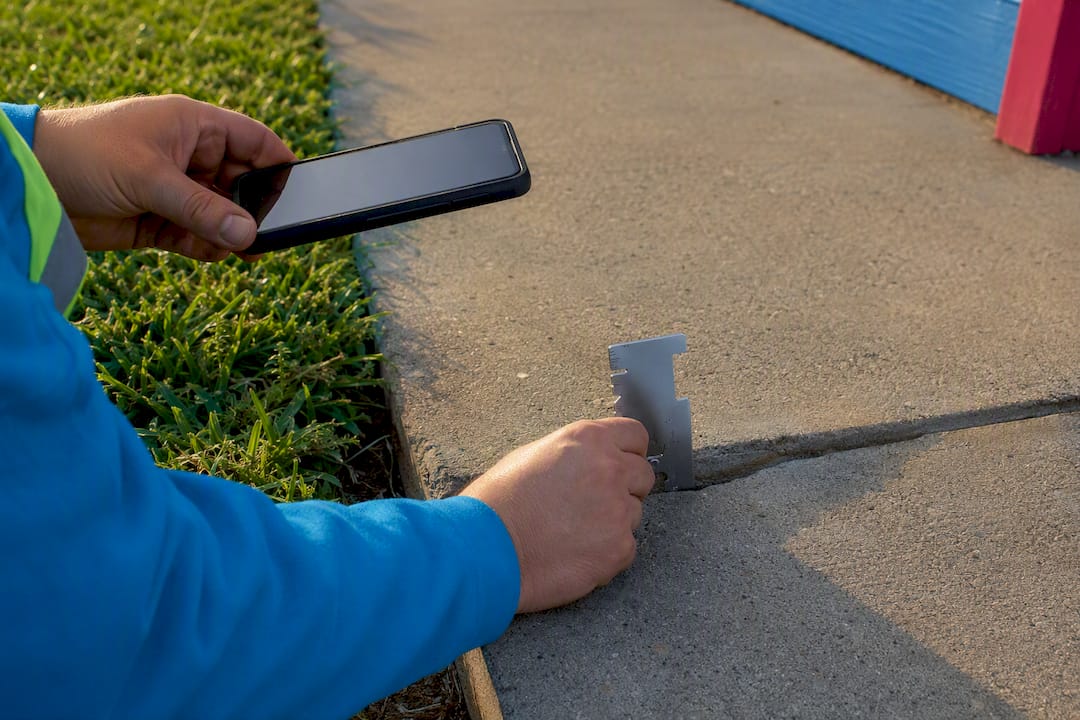 Measuring and photographing sidewalk offset